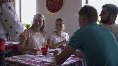 Garson genç şirket insanların kafede içecekler getirmek