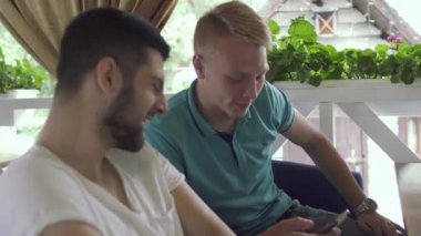 Telefon ekranına bakarak bir şey tartışırken iki genç adam
