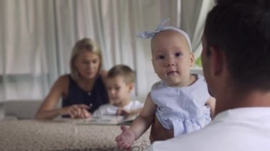 Babası elinden kameraya bakarak kafasına yay ile küçük şirin kız