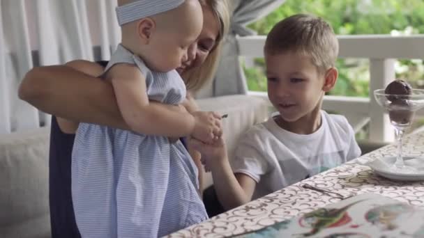 Mały chłopiec bawi się jego siostra dziecko przy stole — Wideo stockowe