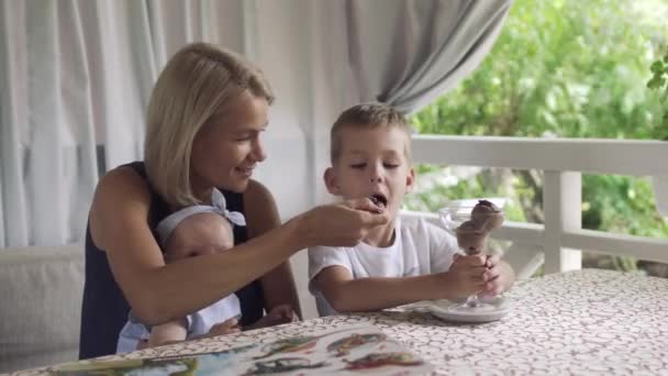 Mother feed her little son with ice cream in cafe — Stock Video