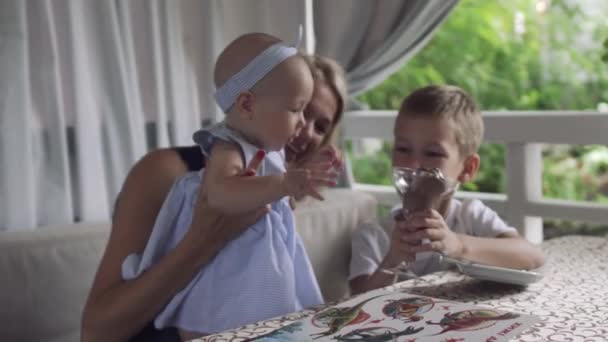Bebé niña trata de agarrar el vaso con helado — Vídeo de stock