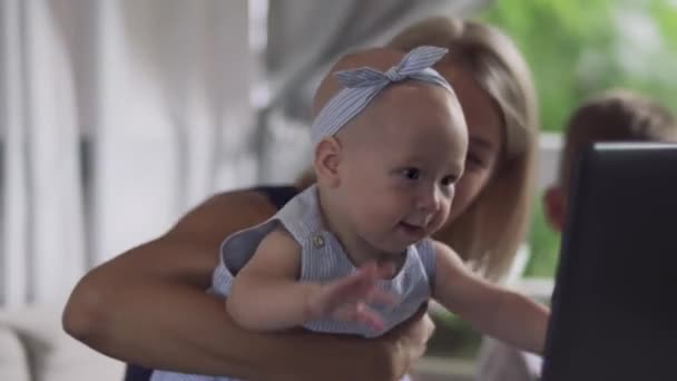 Meisje van de baby is proberen te grijpen scherm van de laptop — Stockvideo