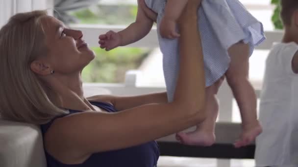 Jovem mãe beija sua filha bebê — Vídeo de Stock