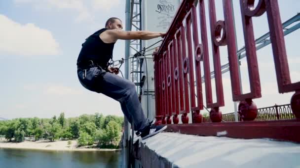 Guy op de brug met de verzekering — Stockvideo