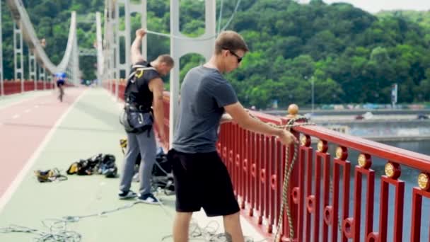 男は橋からジャンプのための安全の世話します。 — ストック動画