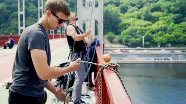 İki adam köprüden atlamak için emanet dikkat çekmek — Stok video