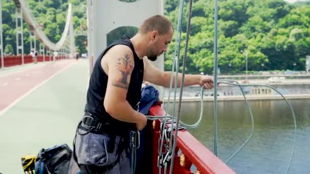 Guy verlaagt het touw voor het springen vanaf de brug — Stockvideo