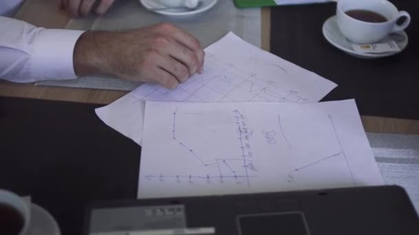 Os papéis com gráficos estão sobre a mesa — Vídeo de Stock