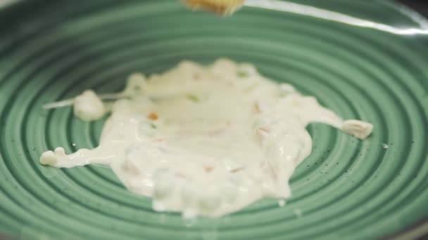 Повар положил тост в белый соус на тарелку. — стоковое видео