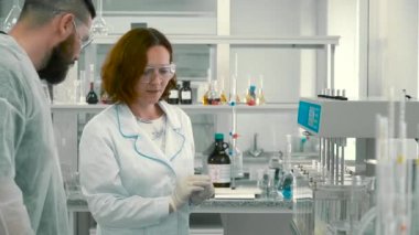 Kadın kimyacı göstermek laboratuvar asistanı donatım ayarlama