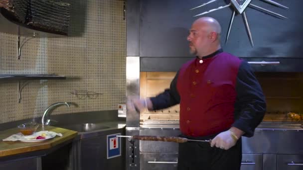 Chef vomir gros couteau et couper la viande sur brochette — Video