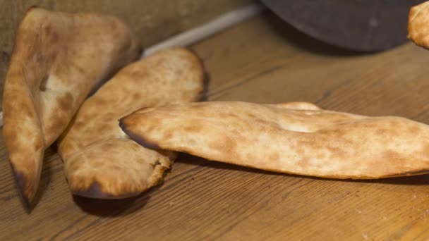 Cook položila na stůl s kovovou holí tradiční chléb shoti — Stock video