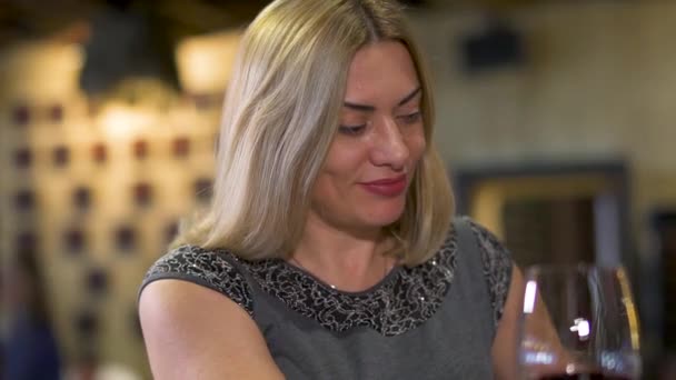Mulher adulta bonita bebendo vinho tinto no restaurante — Vídeo de Stock
