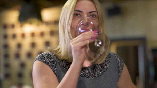 美しい女性がレストランで赤ワインを楽しんでいます — ストック動画