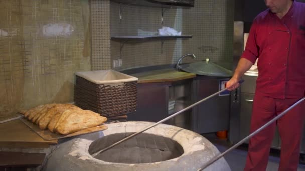 Koken met het bereiden van traditionele brood shoti in tandyr — Stockvideo