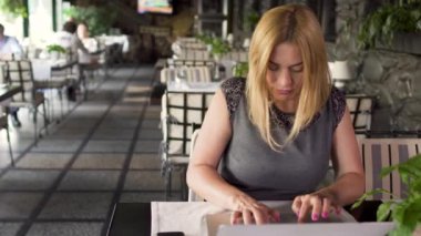 Kadın kafede dizüstü bilgisayarda çalışıyor