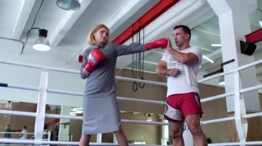 Güzel kadın elbise ve boks eldiven boks ringi koçu ile eğitim