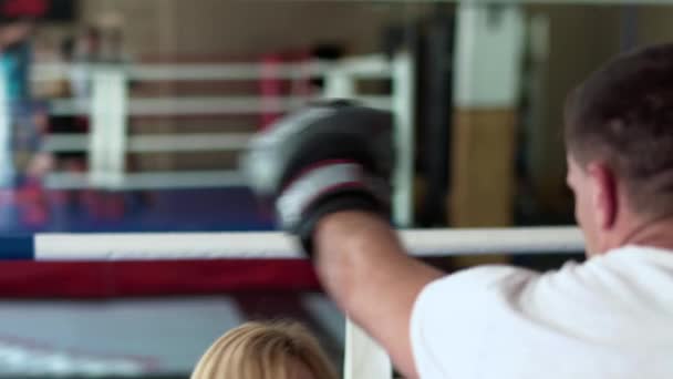 Mulher bonita em luvas de boxe treinamento com treinador — Vídeo de Stock