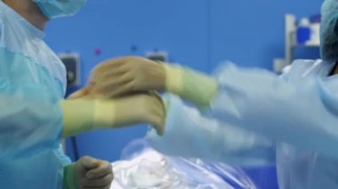 Hemşire yardım cerrah eli üzerinde lateks eldiven koymak