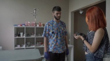 Kızıl saçlı kız hayvan hastalıklarıyla ilgili klinik, küçük bir yavru kedi onun kollarında tutar.