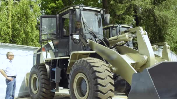 Gerente demuestra comprador cómo el trabajo del tractor — Vídeos de Stock