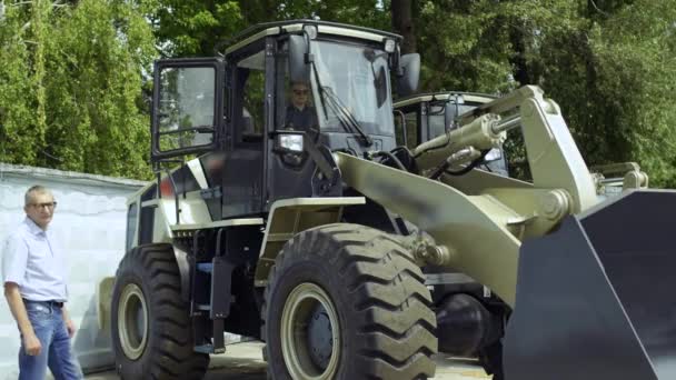 Manager demonstrates buyer how work the tractor — Stock Video