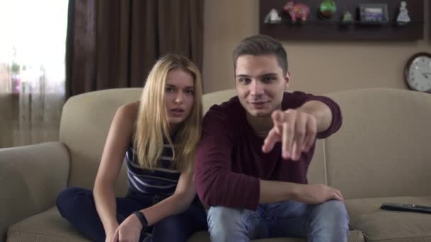 Young couple of teenagers watching tv at home — Stock Video