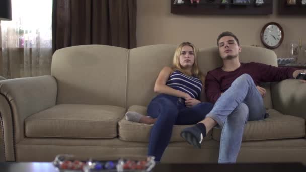 Jovem casal assistindo tv em casa, a menina adormece — Vídeo de Stock