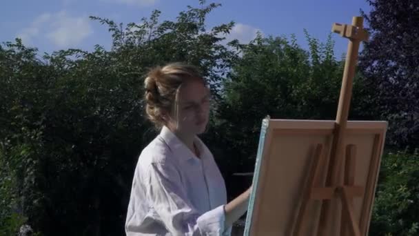 Ung konstnär är angelägen om att rita på bakgården — Stockvideo