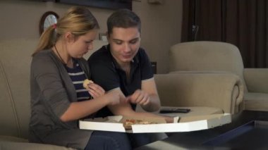 Kanepede oturan ve pizza yemek güzel genç çift
