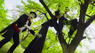 MIME ve sokak sanatçıları stilts üzerinde dalga parkta oynamak