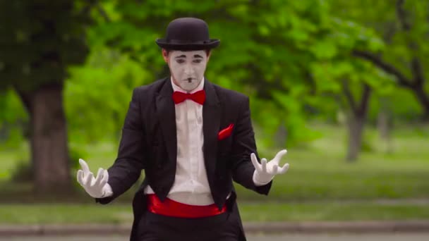 Mime está haciendo malabares con bolas invisibles en el parque — Vídeo de stock