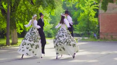 İki güzellik çiftler stilts sokakta dans ediyor
