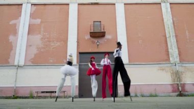 İki çiftler stilts binanın yakınındaki dans ediyor