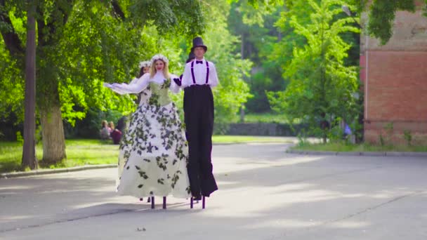 Zwei Paare auf Stelzen tanzen auf der Straße — Stockvideo