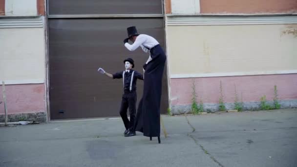 Jeune stilt imite vieil homme près du bâtiment — Video