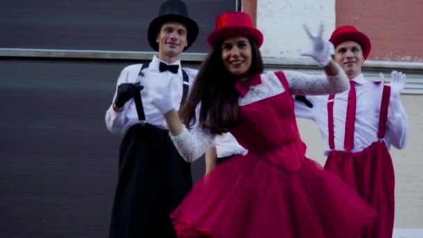 Две пары комиков на ходулях танцуют возле здания — стоковое видео