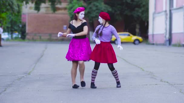 Две мимы девушки показывают себя на улице — стоковое видео