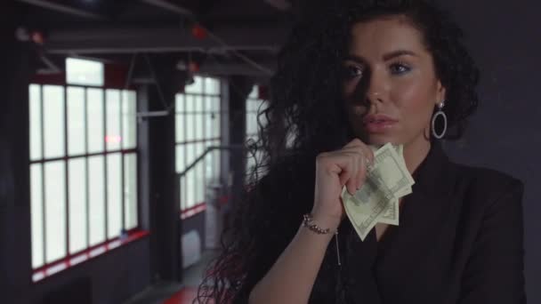 Schöne Brünette mit lockigem Haar hält Geld in der Hand — Stockvideo