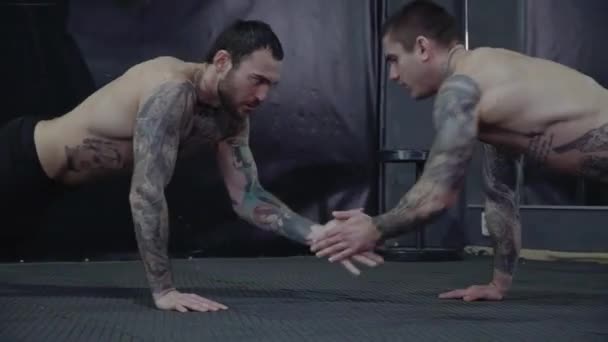 Dva chlapy s tetováním a trenýrky v tělocvičně — Stock video