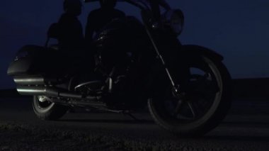 Onların motosiklet ve uzak bir gece şehirde sürme iki bisikletçileri oturmak