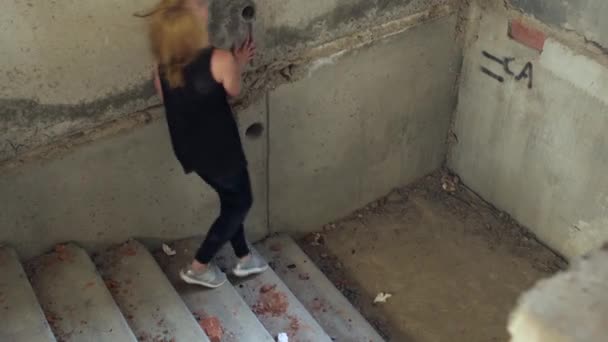 Drug addict descends the stairs in an abandoned building — Stock Video