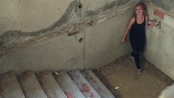 Drogadicto desciende las escaleras en un edificio abandonado — Vídeos de Stock