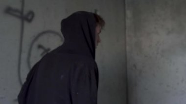 Genç adam bir başlıklı koridorda yürüyor