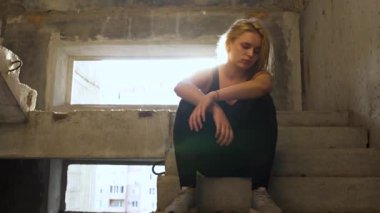 Pasaklı kız terk edilmiş bir binada merdivenlerde oturan