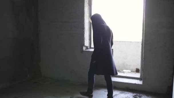 Un joven con capucha camina por el pasillo — Vídeos de Stock