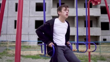 Sağlık, fakir bir durumda genç adam bir salıncağa oturur