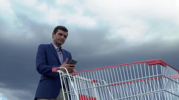 Schöner Mann in Jacke und Hemd hält ein Telefon in der Hand — Stockvideo