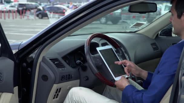 Biznes człowiek siedzi w samochodzie z tabletem — Wideo stockowe